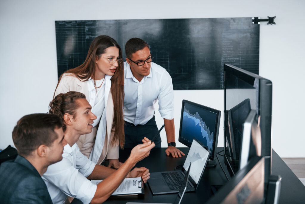 Tracks the graphs. Cybersecurity Team works in modern office with many display screens